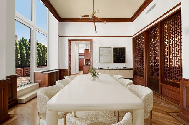 bedroom with crown molding, light hardwood / wood-style floors, and multiple windows