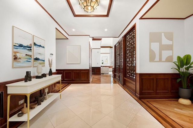 corridor featuring light tile patterned floors, recessed lighting, crown molding, and wainscoting