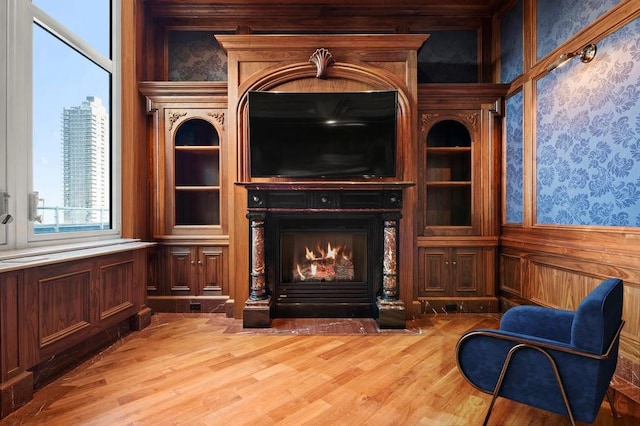 living area featuring a warm lit fireplace and wood finished floors