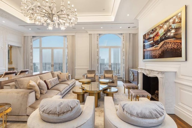 living area featuring a tray ceiling, plenty of natural light, ornamental molding, and hardwood / wood-style flooring