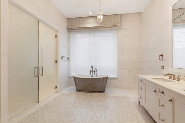 bathroom featuring plus walk in shower, tile walls, tile patterned floors, and vanity