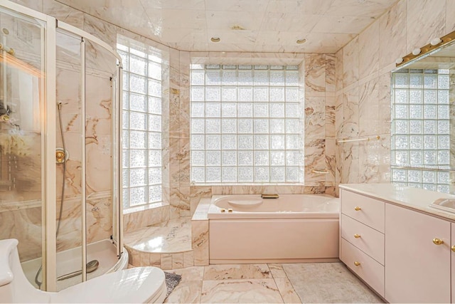 full bathroom with tile walls, vanity, shower with separate bathtub, and toilet