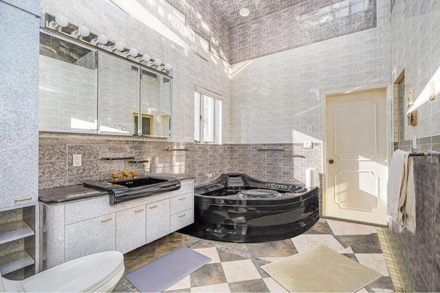 bathroom with a washtub, vanity, a towering ceiling, and tile walls