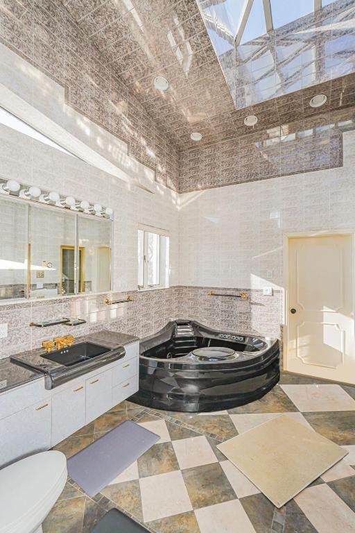 bathroom featuring vanity, a washtub, and tile walls