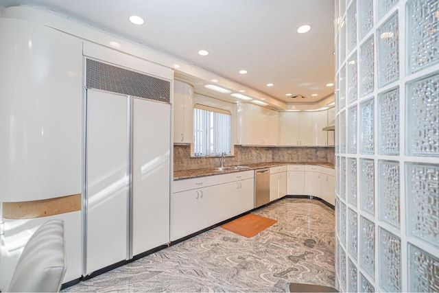 kitchen featuring sink, dishwasher, paneled fridge, white cabinets, and backsplash