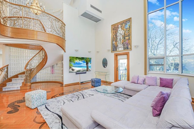 living room with a towering ceiling and a notable chandelier