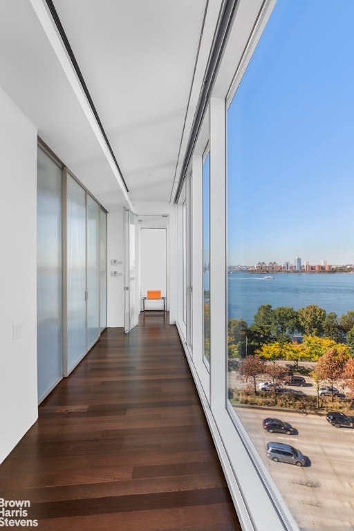 corridor with a water view and dark hardwood / wood-style floors