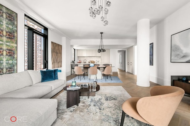 living room featuring light parquet floors and an inviting chandelier