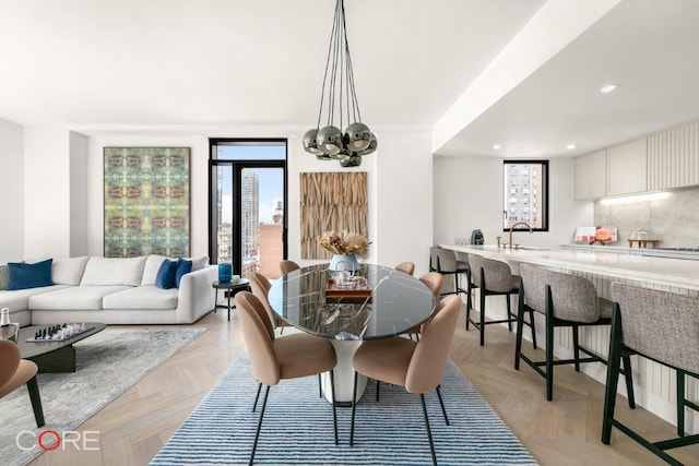 dining room featuring light parquet floors, sink, and an inviting chandelier