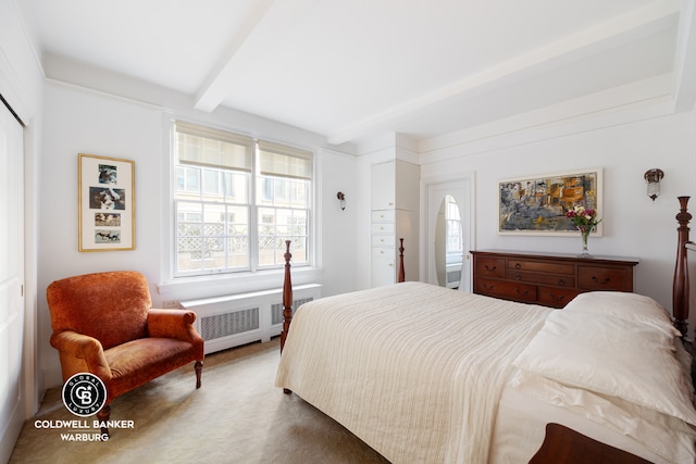 bedroom with beam ceiling, radiator heating unit, and carpet flooring