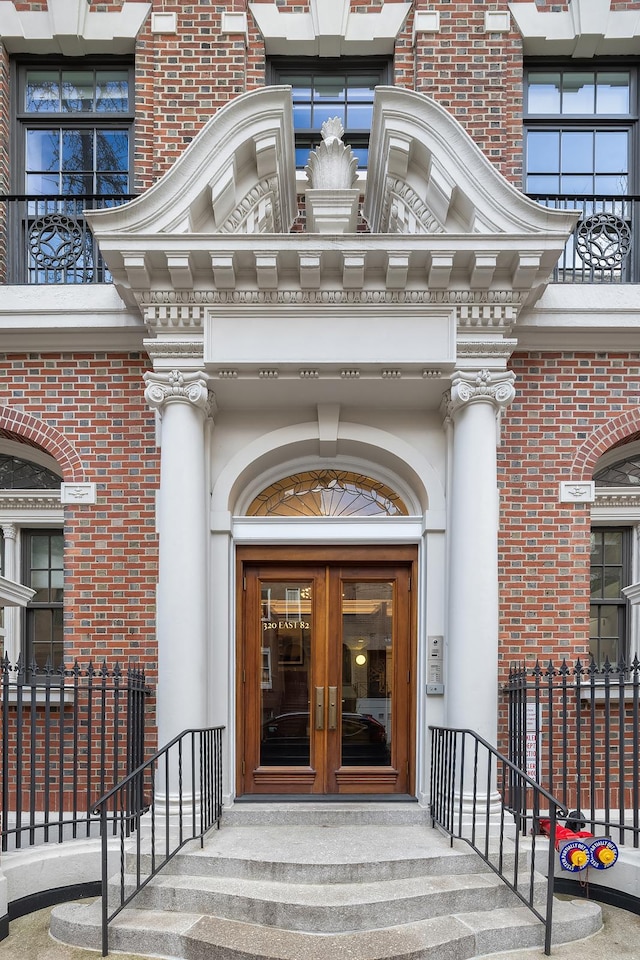 entrance to property featuring brick siding and french doors