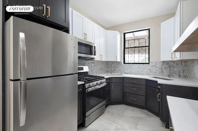 kitchen featuring stainless steel appliances, decorative backsplash, white cabinetry, and sink