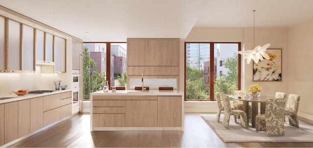 kitchen featuring light countertops, light brown cabinetry, modern cabinets, and a healthy amount of sunlight