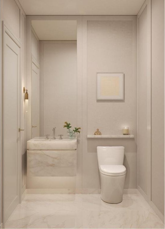 bathroom with marble finish floor, a sink, and toilet