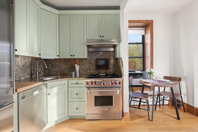 kitchen featuring sink, exhaust hood, green cabinets, and stainless steel appliances