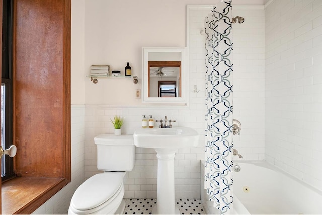 bathroom featuring tile walls, toilet, and shower / bath combo