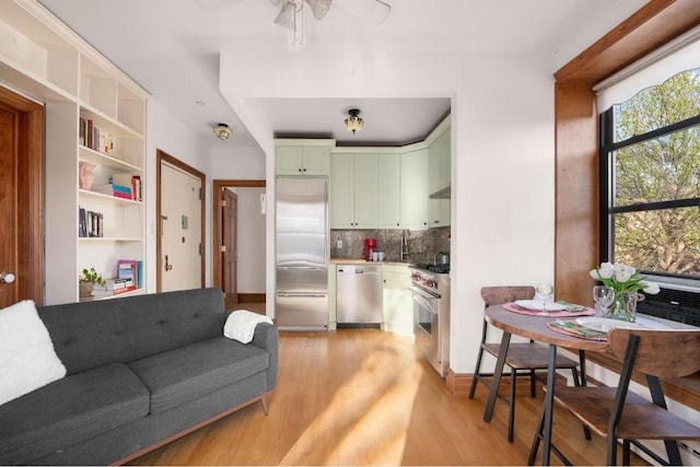 living room with ceiling fan and light wood-type flooring