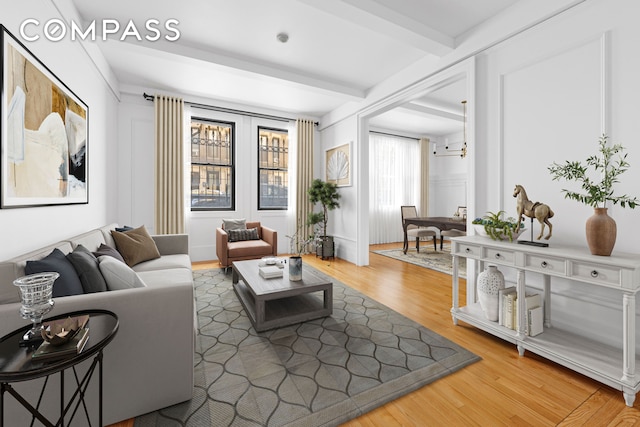 living area featuring beamed ceiling and wood finished floors