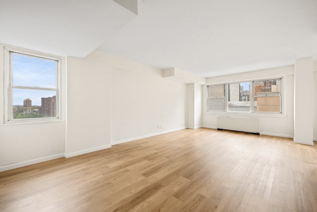 interior space featuring radiator heating unit and light wood-type flooring