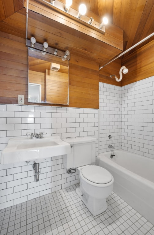 full bathroom with sink, tiled shower / bath, tile patterned floors, and toilet