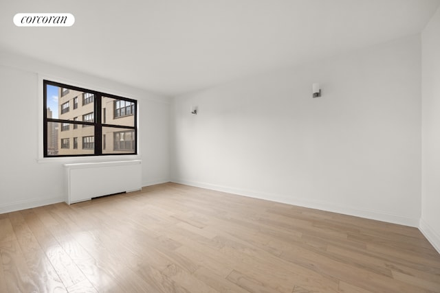 empty room with radiator and light hardwood / wood-style flooring