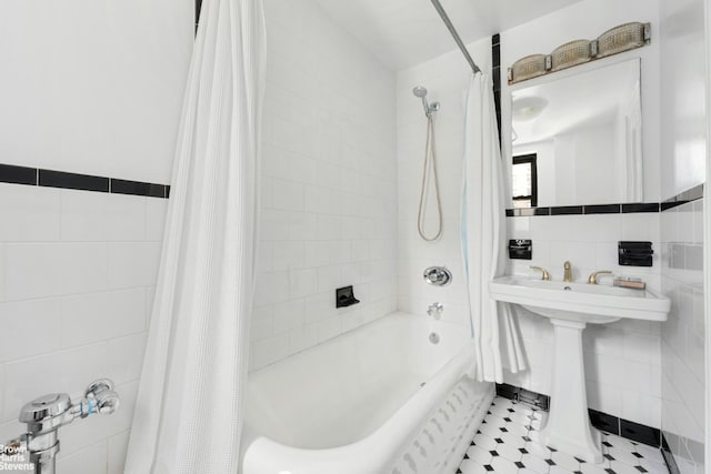 bathroom with sink, tile walls, and shower / bathtub combination with curtain