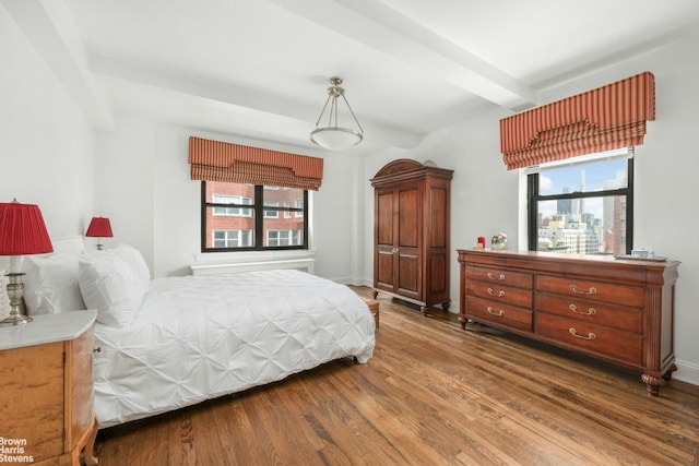 bedroom featuring dark hardwood / wood-style flooring and beamed ceiling