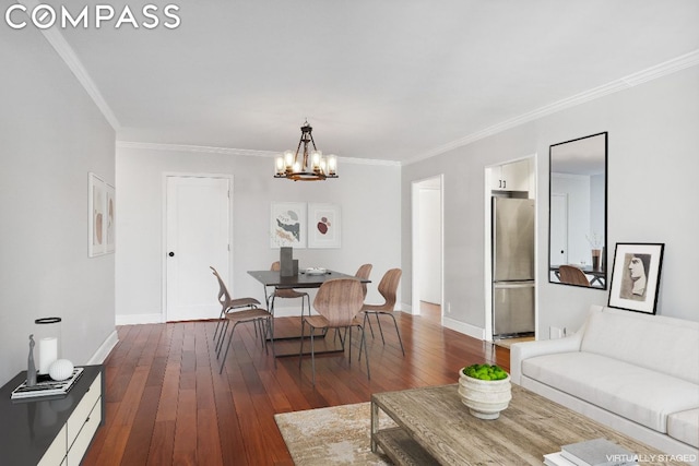 living room with crown molding, dark wood-type flooring, and an inviting chandelier