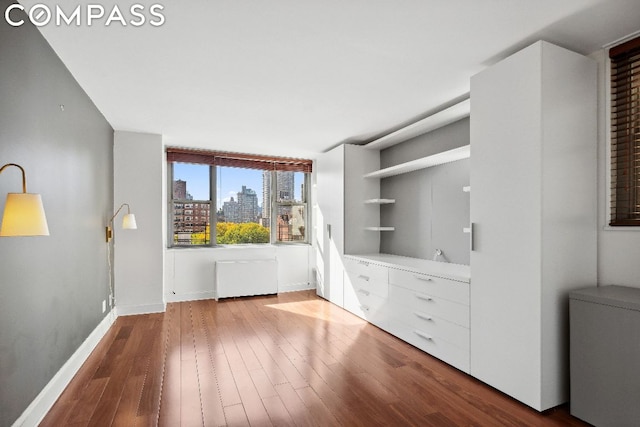 interior space with wood-type flooring and radiator heating unit