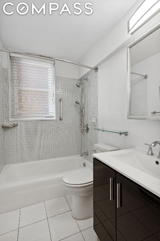 full bathroom with toilet, vanity, tile patterned floors, and tiled shower / bath