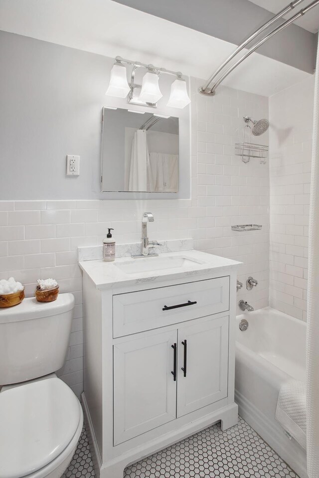 full bathroom with shower / tub combo with curtain, vanity, toilet, and tile walls