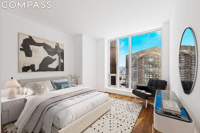 bedroom with hardwood / wood-style floors and expansive windows