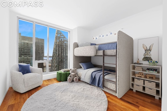 bedroom with hardwood / wood-style flooring and multiple windows