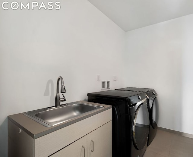 clothes washing area featuring cabinets, tile patterned flooring, washing machine and clothes dryer, and sink