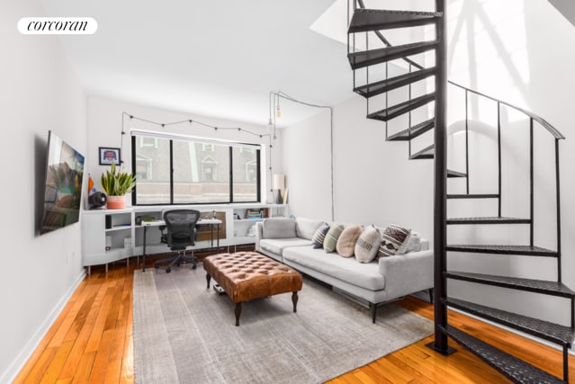 living area featuring baseboards, stairway, visible vents, and hardwood / wood-style flooring