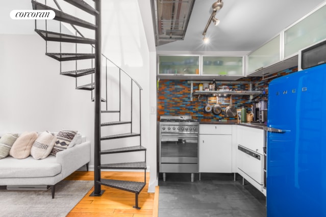 kitchen with high end stainless steel range oven, dark wood-type flooring, and white cabinetry