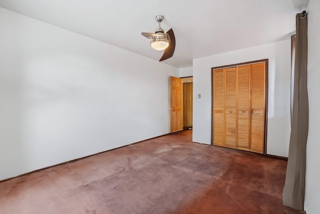 unfurnished bedroom with ceiling fan, a closet, and dark colored carpet