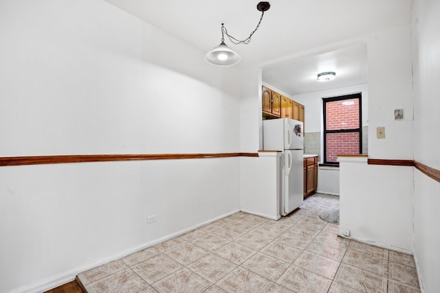 kitchen featuring white refrigerator and pendant lighting