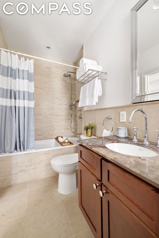 full bathroom with toilet, vanity, tile patterned floors, and shower / bath combo with shower curtain