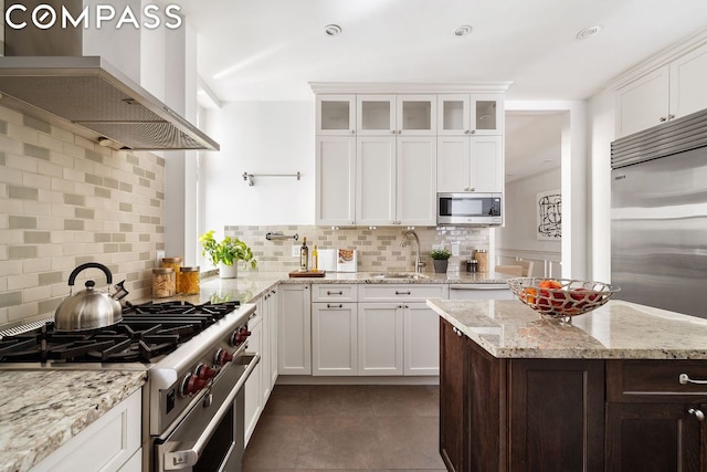 kitchen with sink, wall chimney range hood, white cabinets, and stainless steel appliances