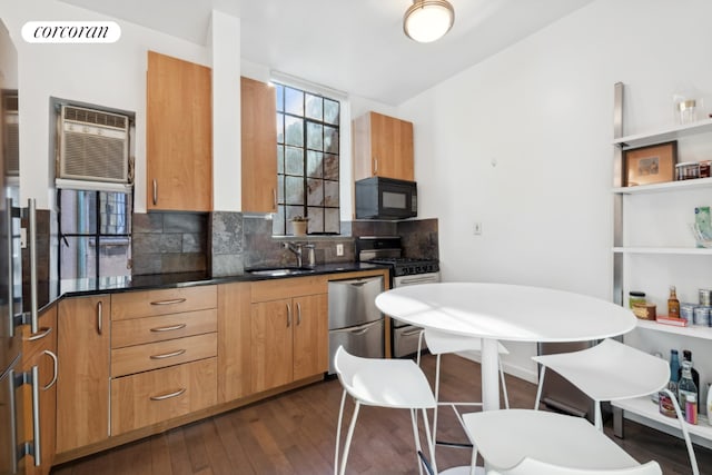 kitchen featuring decorative backsplash, stainless steel gas range oven, sink, dark wood-type flooring, and dishwashing machine