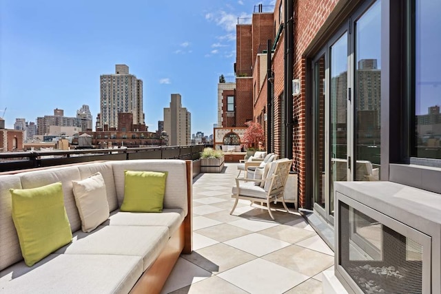 view of patio featuring a view of city, a balcony, and an outdoor hangout area