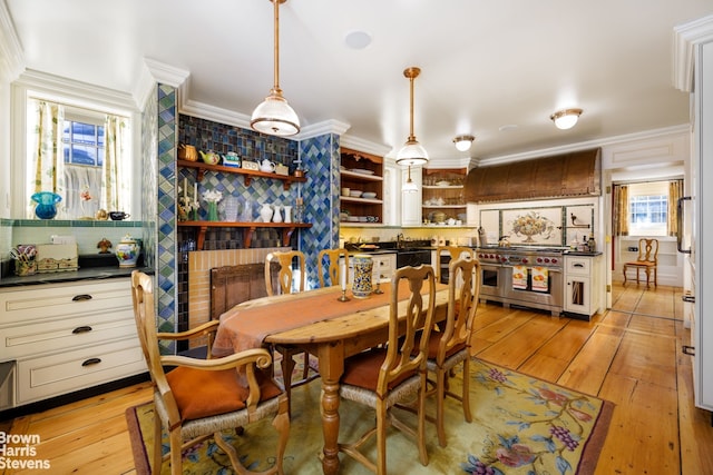 dining area featuring ornamental molding and light hardwood / wood-style floors