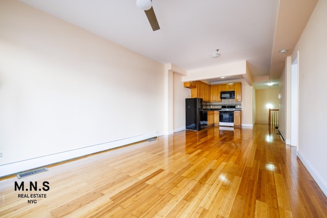 unfurnished living room featuring a ceiling fan, visible vents, light wood-style flooring, and baseboards