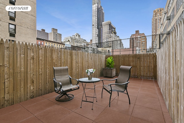 view of patio featuring a view of city and fence