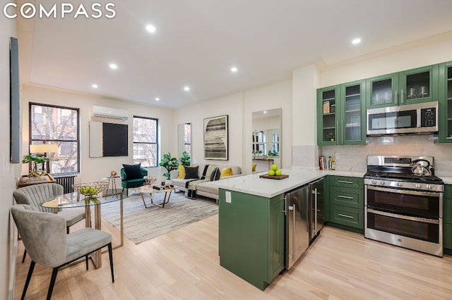 kitchen with kitchen peninsula, green cabinets, a wall mounted air conditioner, stainless steel appliances, and beverage cooler