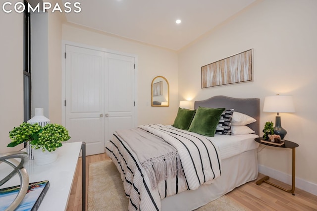 bedroom with light wood-type flooring and a closet