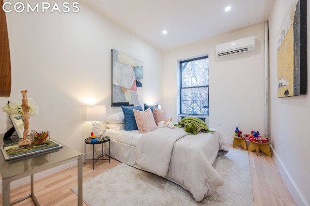 bedroom featuring a wall mounted AC and hardwood / wood-style flooring