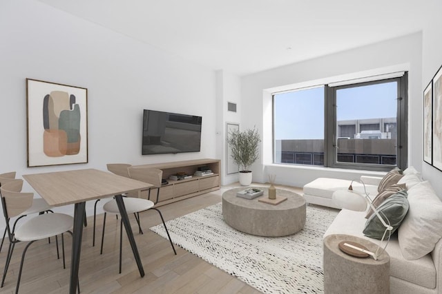 living room featuring visible vents and wood finished floors