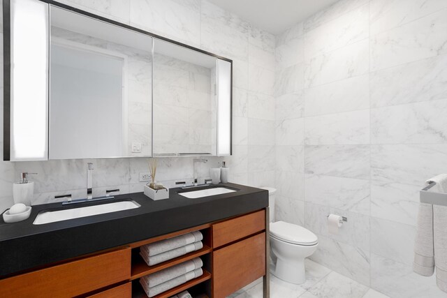 75 Wall St Unit 31P, New York City, NY 10005 - bathroom with double vanity, tile walls, toilet, and backsplash